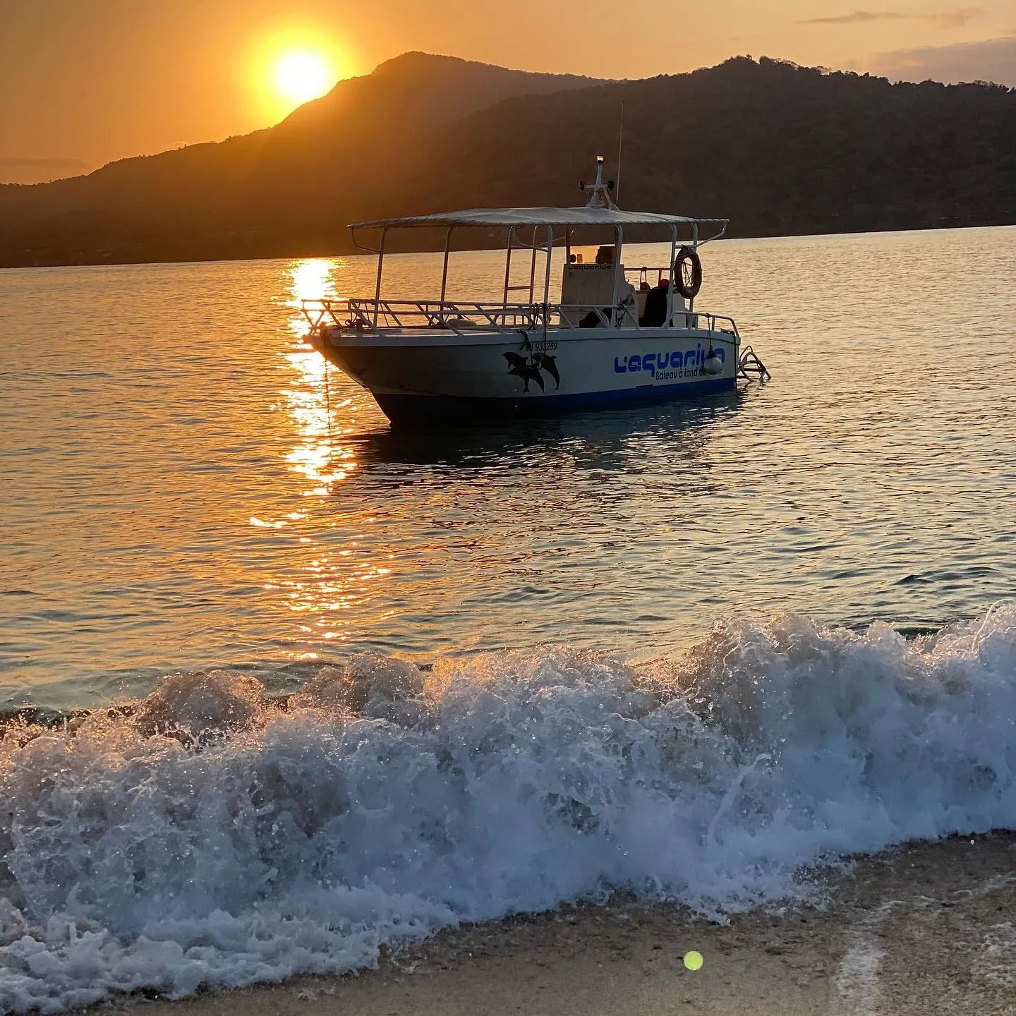 Le bateau au mouillage devant un îlot, soleil couchant derrière la crête