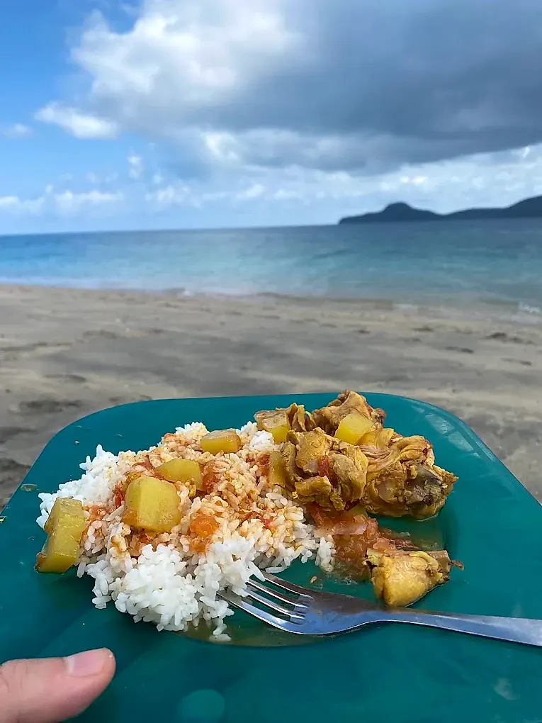 Le repas chaud servi sur la plage : riz, cari et légumes, face au lagon